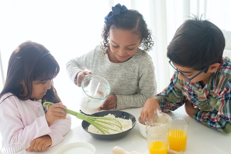 Three children making pancakes.